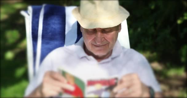 Старший Чоловік Читає Відкритому Повітрі Насолоджуючись Пенсією — стокове відео