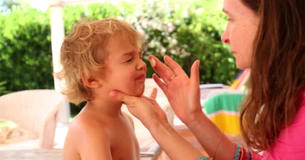 幼児の男の子に日焼け止めを適用する母親 — ストック動画