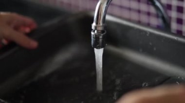 Closeup of hands washing dishes