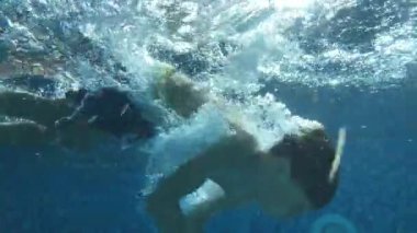 Child swimming underwater at the pool