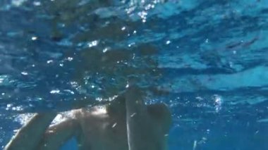 Child at the swimming pool, seen underwater
