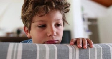 Child boy grimace, kid sticking out tongue
