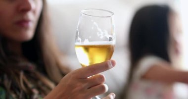 Sohbet ederken elinde bira bardağı tutan kadın.