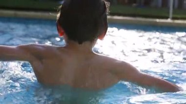 Kid at the swimming pool, young boy going underwater, diving