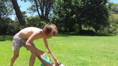 Siblings wrestling and fighting each other in rivalry, camera lands on the ground