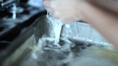 Closeup of hands washing dishes