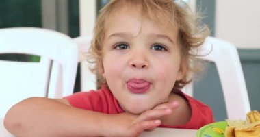 Child boy sticking tongue out to camera