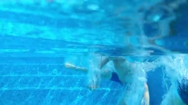 Çocuklar havuza atlıyor ve süper yavaş çekimde suyun altına giriyorlar.