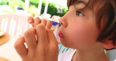 Close-up of child face eating a chewing. Kid eating breakfast