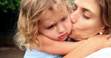 Anne kızını kucaklıyor ve sevgisini paylaşıyor, öpüşüyor.