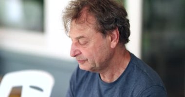 Older retired man taking a sip of coffee or tea