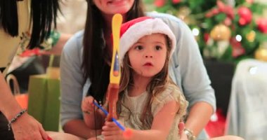 Küçük kız okçuluk oyuncağı Noel hediyesiyle oynuyor.