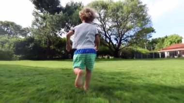 Boy toddler running in home garden outdoors