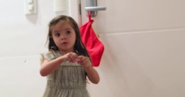 Sevimli küçük kız Noel Baba çorabını kontrol ediyor.