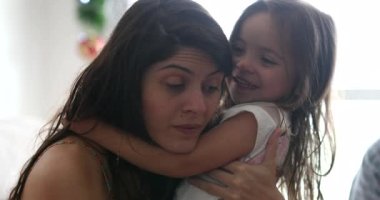 Küçük kızlar anne kulaklarına bir sır fısıldıyor, gerçek hayat gülüşü samimi ve otantik