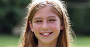 küçük kız kameraya gülümseyen