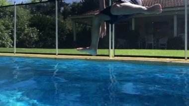 Child jumping inside swimming pool water in super slow-motion