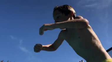 Çocuk yüzme havuzuna atlıyor, genç çocuk suyun altında.