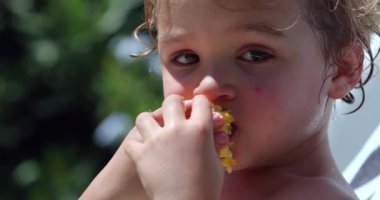 Baby boy eating corn