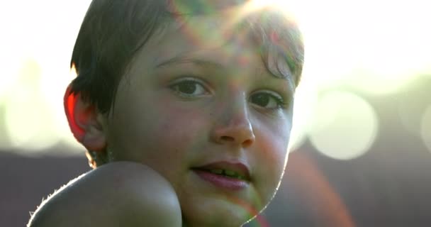 Красивый Мальчик Смотрит Камеру Солнечной Вспышкой — стоковое видео