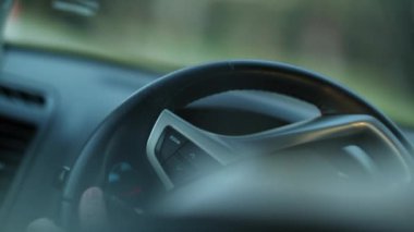 Person driving, making a left turn, holding steering wheel