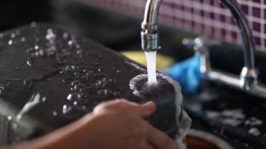 Closeup of hands washing dishes