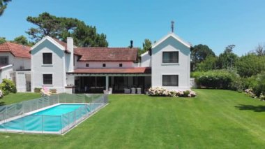 Suburban home exterior with lawn and swimming pool