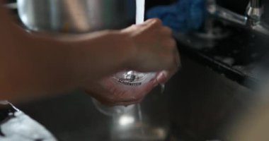 Hands washing glass dishes