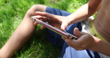 Child hands holding smartphone playing games
