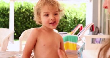 Anne oğluna güneş kremi sürüyor.