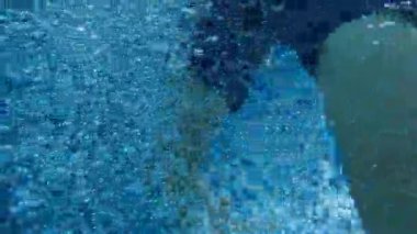 Young boy emerging from underwater, clearing face