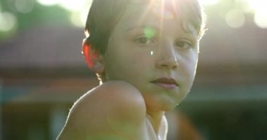 Portrait of handsome kid outdoors with sunlight flare