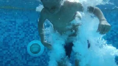 Young boy jumping inside water