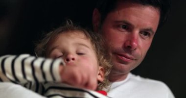 Baba kucağında uyumak isteyen bebe bir çocuk. Samimi, bitkin çocuk