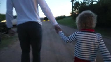 Bebek, babasıyla el ele tutuşuyor.