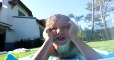 Yakışıklı çocuk çimlerin üzerinde yatıyor.