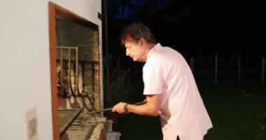 Older man preparing bbq grill at home, casual