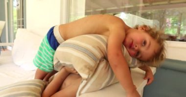 Bebek, kardeş bedenine yastık bastırıyor.