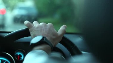 Person holding steering wheel driving, close-up of hands