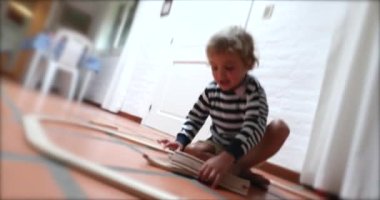 Baby boy playing with wooden car toy roads
