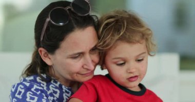 Anne ve küçük bebek birlikte. Anne öpüyor ve sarılıyor evlat, samimi, gerçek hayat.