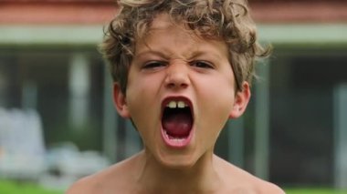 Portrait of young boy shouting in slow-motion. Child screaming from top of his lungs in 120fps