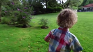 Kid running outside, child boy runs in outdoor garden