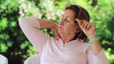 Contemplative older woman in her 60s eating biscuit crackers. Casual and candid real life scene