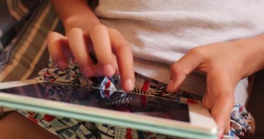 Child hands touching tablet screen. Young boy holding device