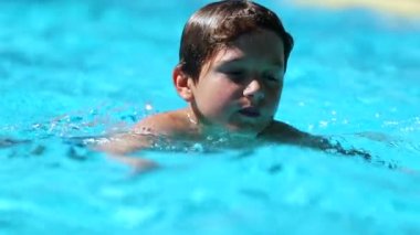 Child swimming at the pool. Slow-motion 120fps of young boy swimming