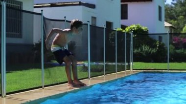 Child falling inside swimming pool water in slow-motion