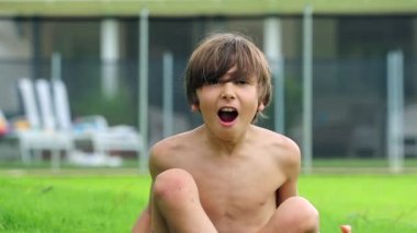 Young boy screaming from the top of his lungs in slow-motion. Child yelling outside