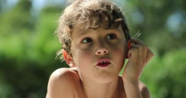 Portrait of candid little boy hanging outside. Young boy