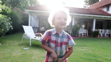 Toddler boy outside in backyard home with sunlight shining
